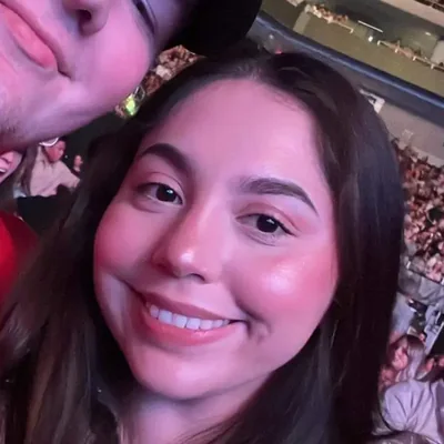 Thalia smiling in a selfie taken in a crowded arena